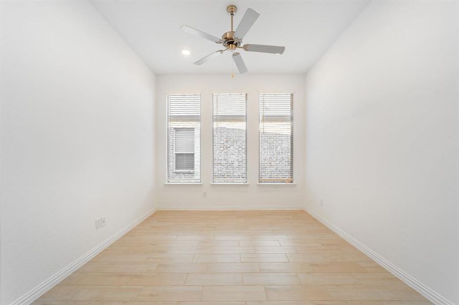 Empty room with light hardwood / wood-style floors and ceiling fan