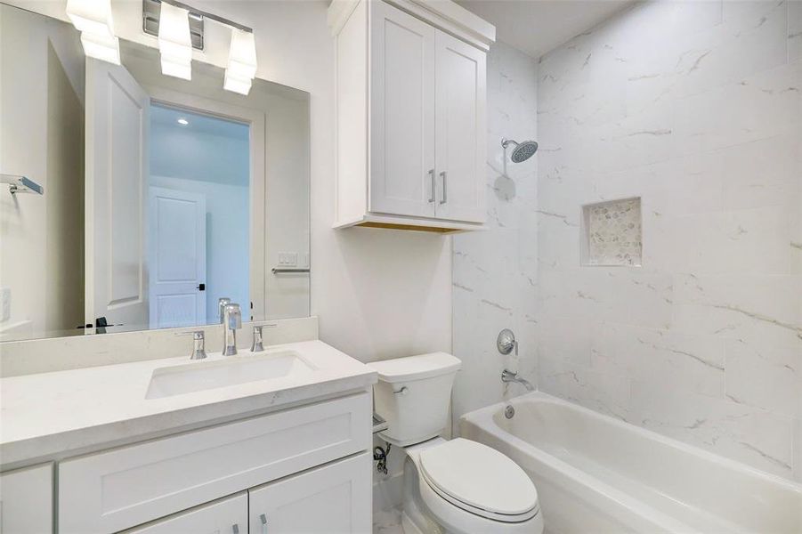 SAMPLE - Auxiliary bedroom features en suite bathroom with Calcatta Quartz countertops and slab quartz tub enclosure to the ceiling.  There is also an auxiliary bedroom with en suite bath featuring walk-in shower.