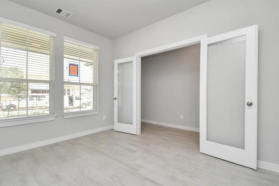 Quietly nestled in front of the home is the sophisticated home office. Featuring elegant flooring, custom paint and large window.