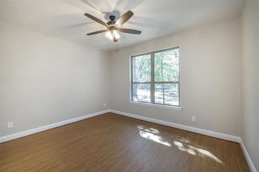 Spare room featuring ceiling fan and dark wood-type flooring