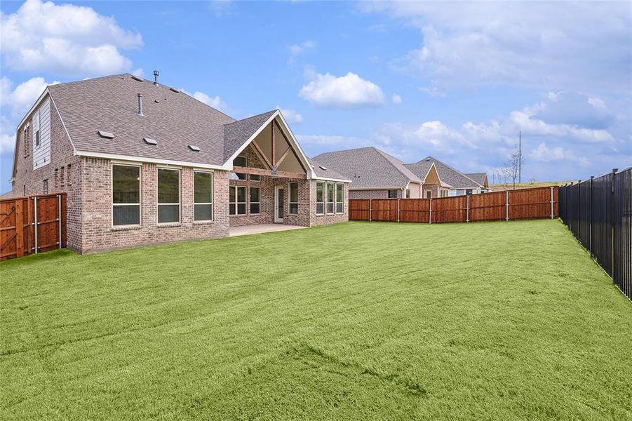 Back of house featuring a lawn and a patio