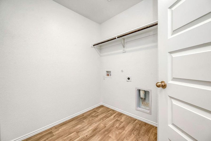 Washroom with light wood-type flooring, washer hookup, hookup for a gas dryer, and electric dryer hookup