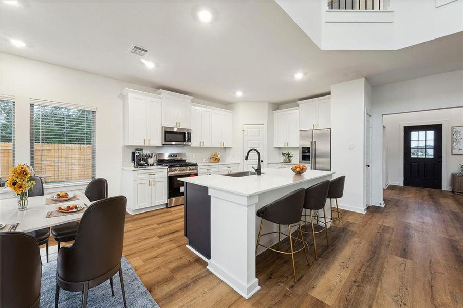 The large island serves as a central hub, ideal for meal prep and casual dining, while the open floor plan ensures easy flow between the kitchen, dining area, and living spaces.