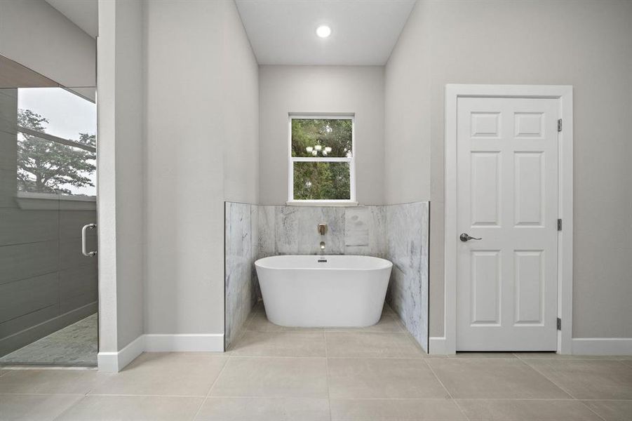 Matching marble surrounds tub and used as accent in large shower. Door on the right allows for privacy when using the commode.