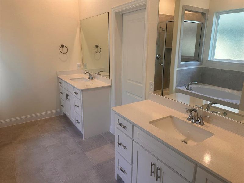 Bathroom featuring tile patterned flooring, vanity, and separate shower and tub