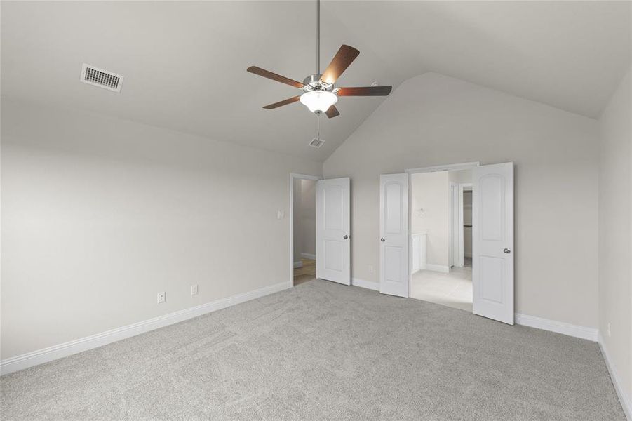 Unfurnished bedroom featuring high vaulted ceiling, ceiling fan, and light colored carpet