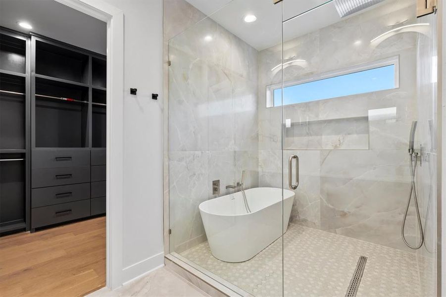 Bathroom featuring wood-type flooring and shower with separate bathtub