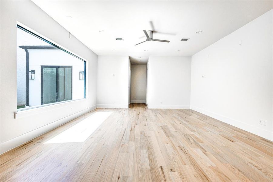 Empty room with light hardwood / wood-style flooring and ceiling fan