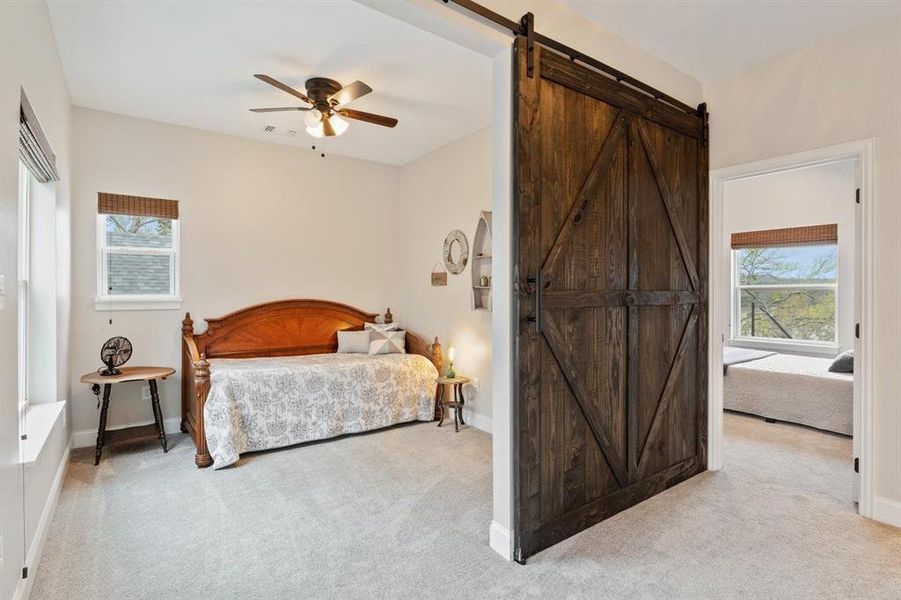At the Top of the Stairs is a Cozy Guest Bedroom with Farmhouse Barn Door