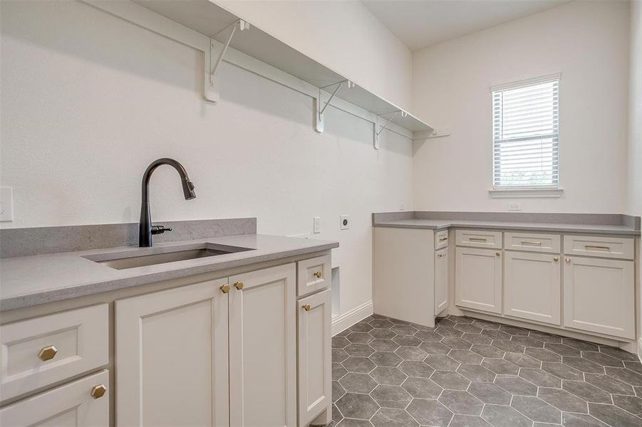 Utility room featuring tile flooring, sink, built-in cabinets, and full size W/D hookups