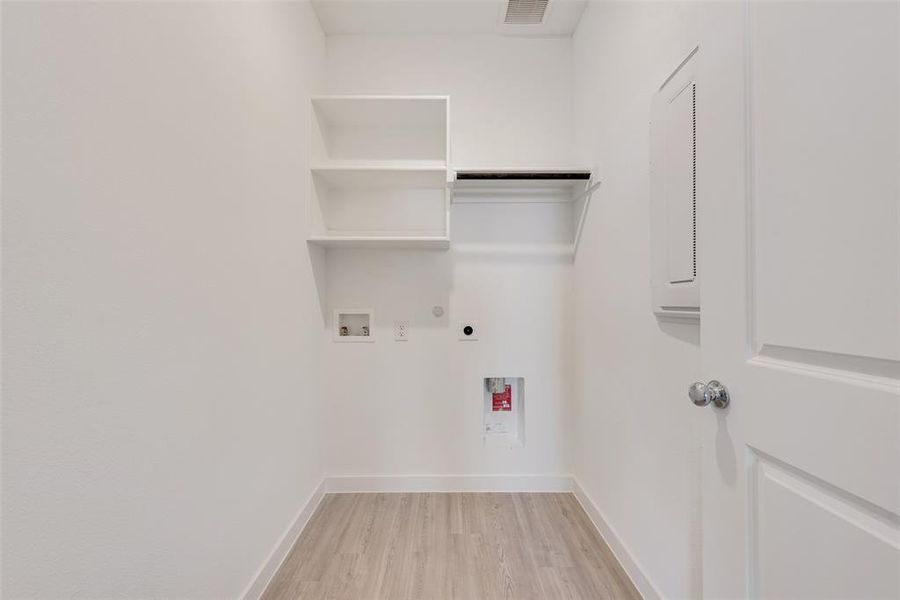 Laundry room with hookup for a gas dryer, light hardwood / wood-style flooring, electric dryer hookup, and washer hookup