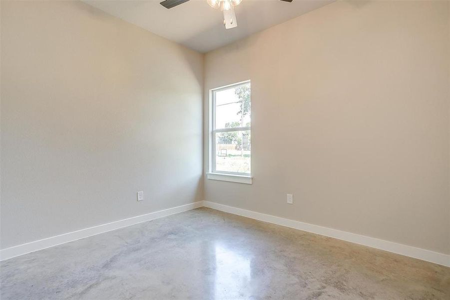 Spare room with ceiling fan and concrete floors