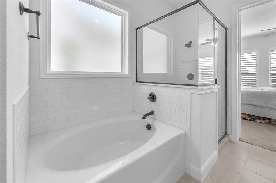 Bathroom featuring tile patterned floors, ceiling fan, and separate shower and tub