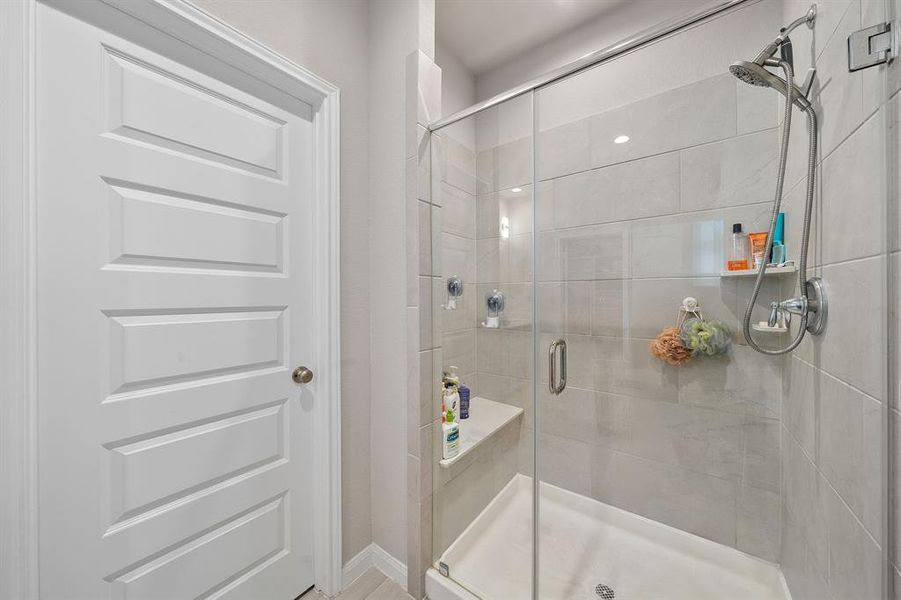 This additional view of the primary bath showcases a huge spa like walk-in shower with tile surround, perfect for soaking after a long day.