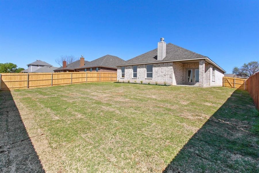 Rear view of house featuring a lawn