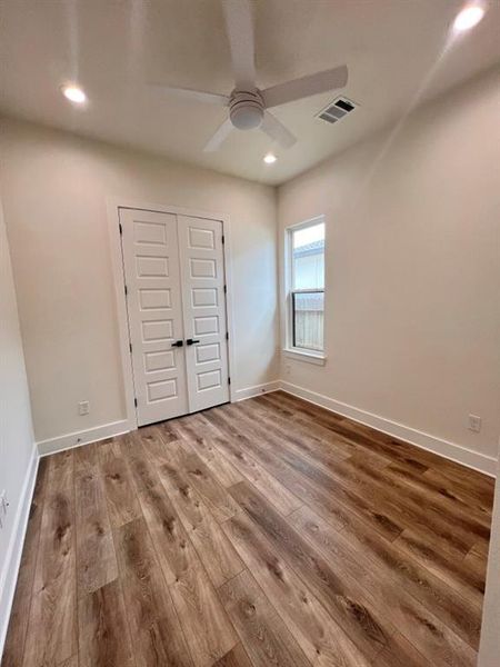 A bright white room featuring wooden floors and elegant white doors, creating a clean and spacious atmosphere.