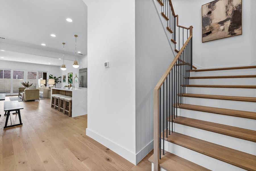 Stairs with hardwood / wood-style floors and sink