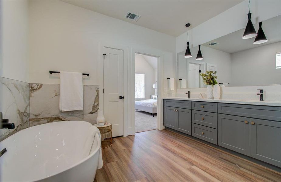 Spacious and luxurious primary bathroom boasts double sinks and stand alone soaking tub.