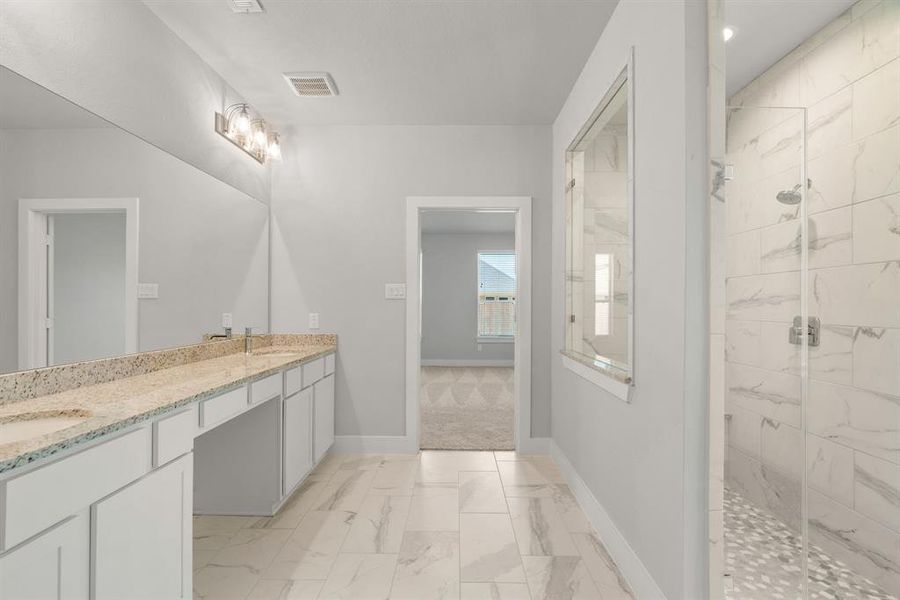 This additional view of the primary bath features a walk-in shower with the tile surround. Sample photo of completed home with similar floor plan. Actual colors and selections may vary.