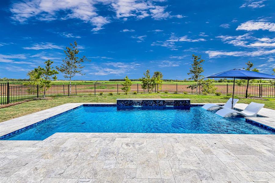 The custom pool was recently built and features a pool ledge with loungers and umbrella, two waterfalls, and a bubbler. No rear neighbors and unhampered views of the luminous Fulshear sunsets!