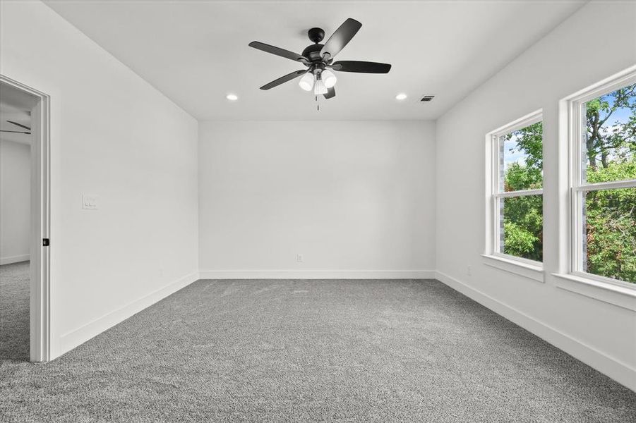 Spare room featuring ceiling fan and carpet