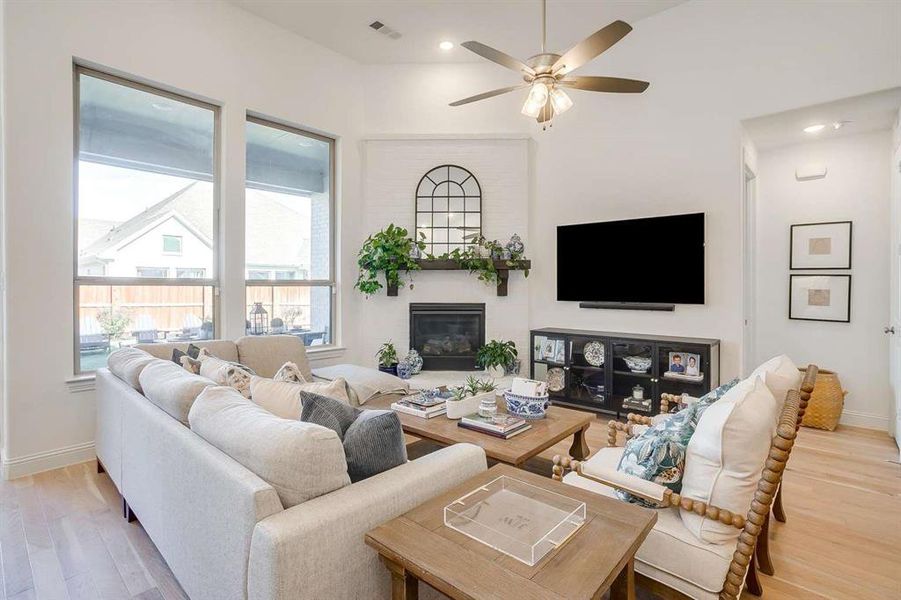 Living room with ceiling fan and light hardwood / wood-style flooring