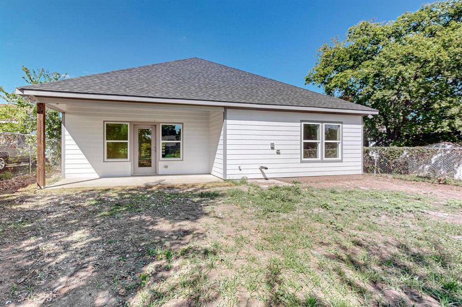 Rear view of property with a lawn and a patio area