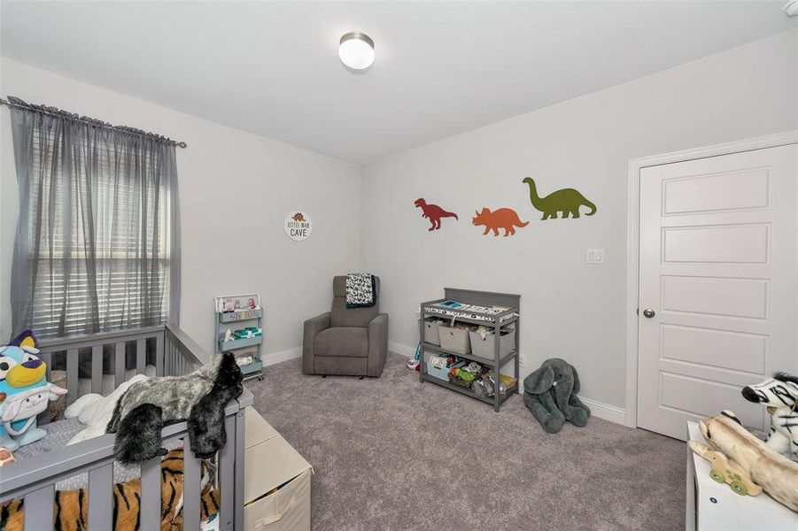 Bedroom with carpet floors and a crib