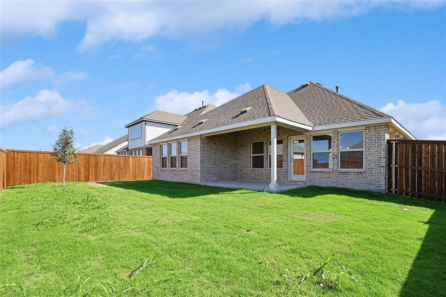 Back of property with a yard and a patio area