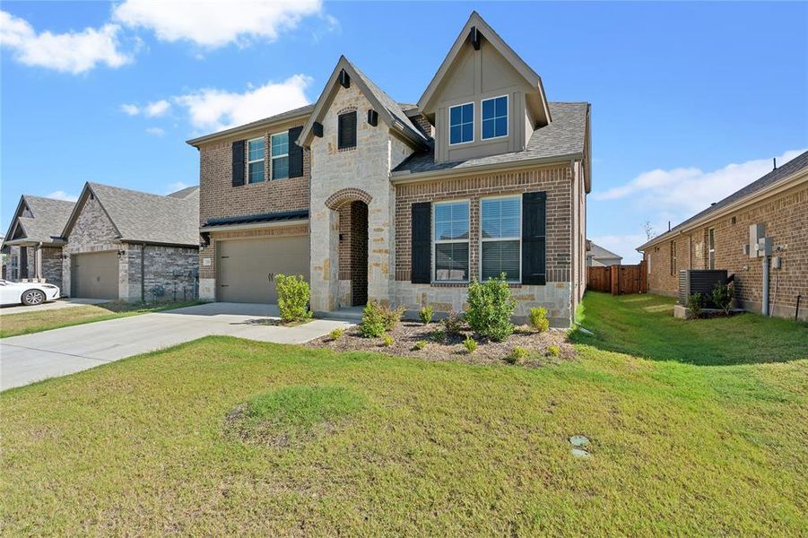 View of front of property with a front lawn, central air condition unit, and a garage