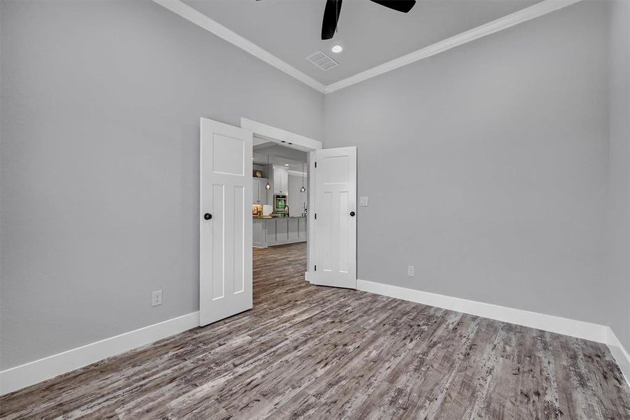 Spare room featuring ceiling fan, hardwood / wood-style floors, and crown molding