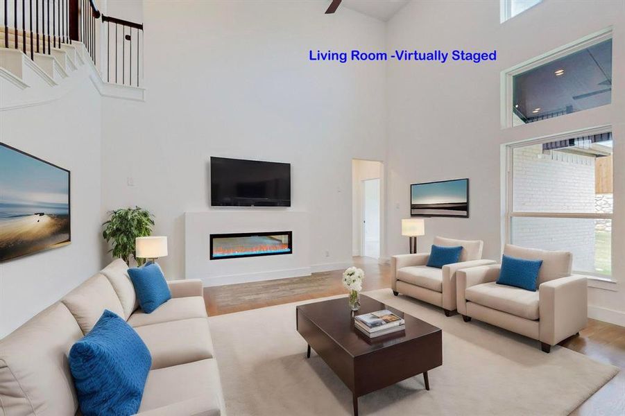 Living room with wood-type flooring and a towering ceiling