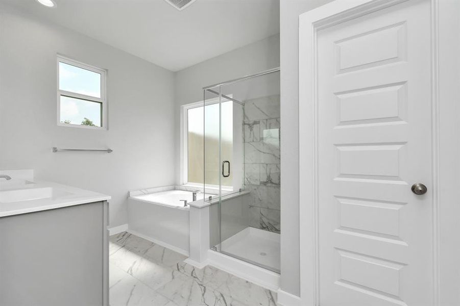 Immerse yourself in a luxurious retreat within the confines of your main bathroom. Enjoy the roomy walk-in shower encased in stylish tile, take a moment to unwind in a separate garden tub embellished with custom details.