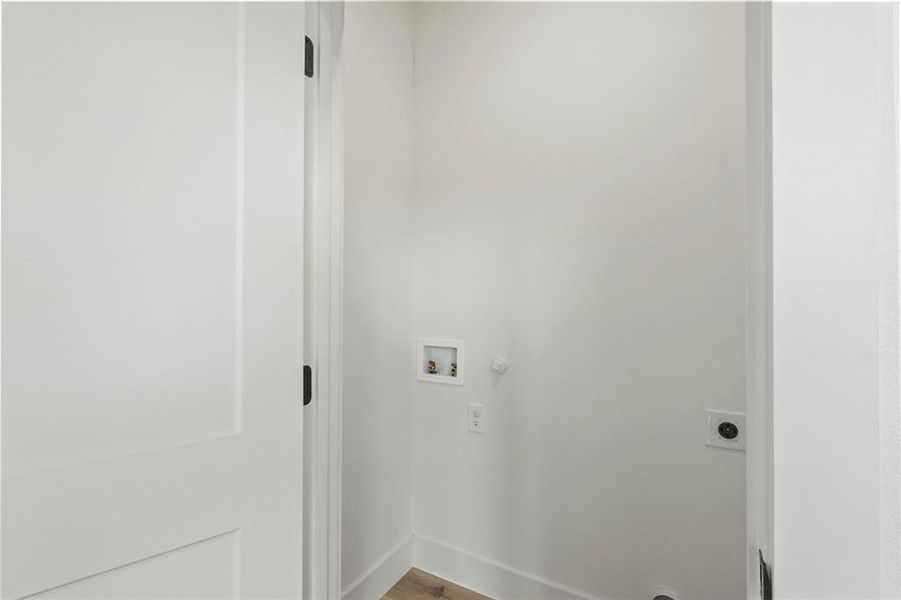 Laundry room featuring wood-type flooring, hookup for a washing machine, and electric dryer hookup