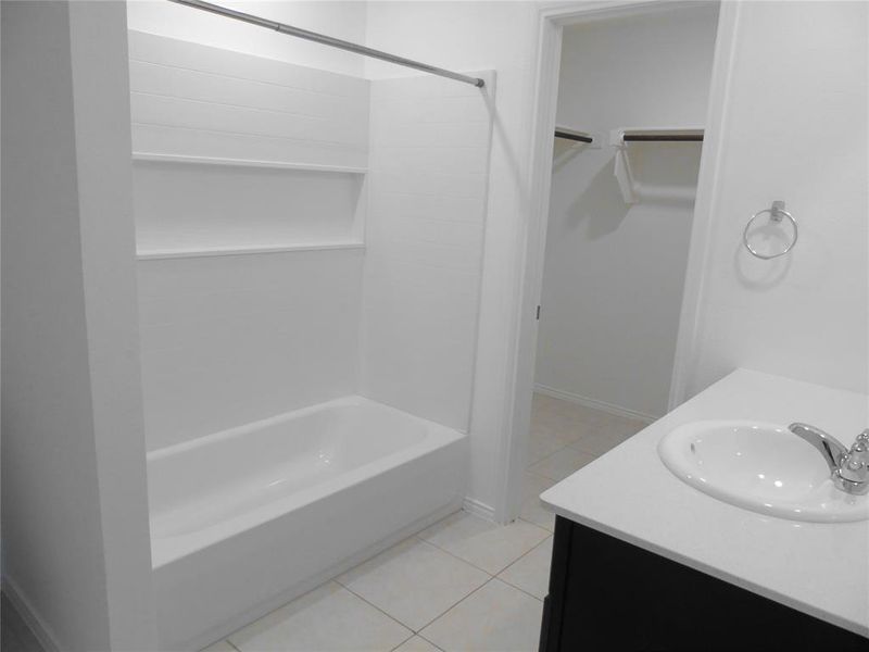 Bathroom with tile patterned flooring, vanity, and bathtub / shower combination