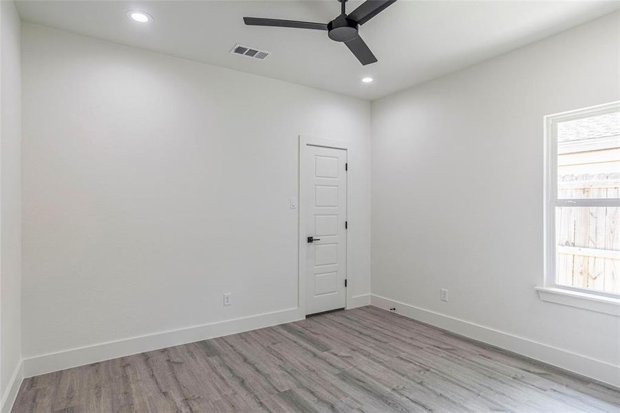 Spare room featuring ceiling fan, hardwood / wood-style flooring, and a wealth of natural light