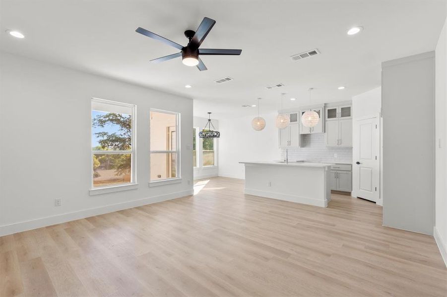 Unfurnished living room with ceiling fan and light hardwood / wood-style floors