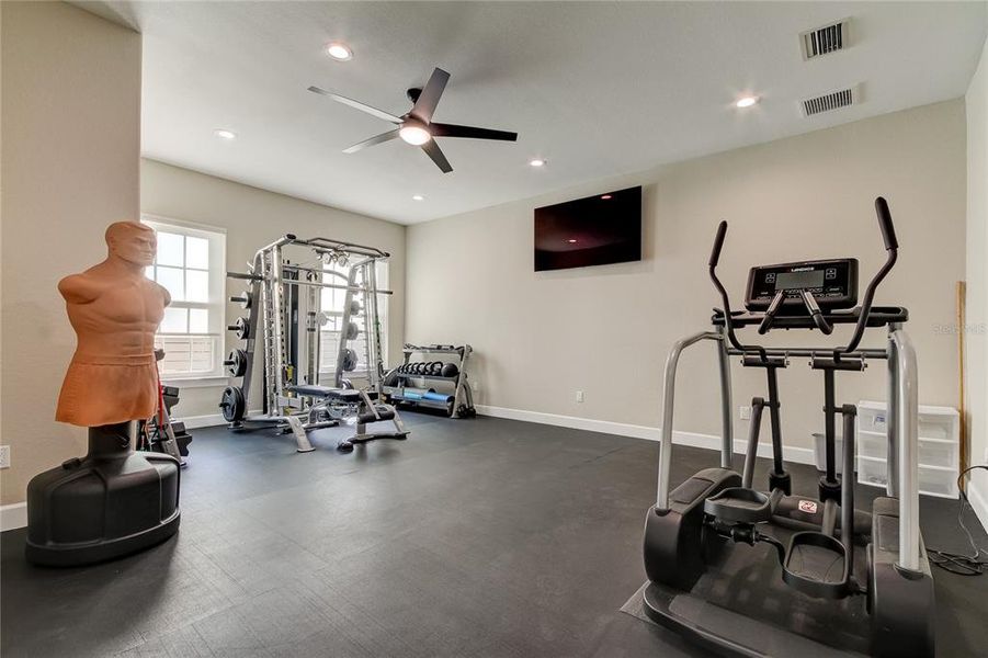 Versatile 23'x18' room on ground floor, with adjacent full bath, currently used as oversized fitness room.