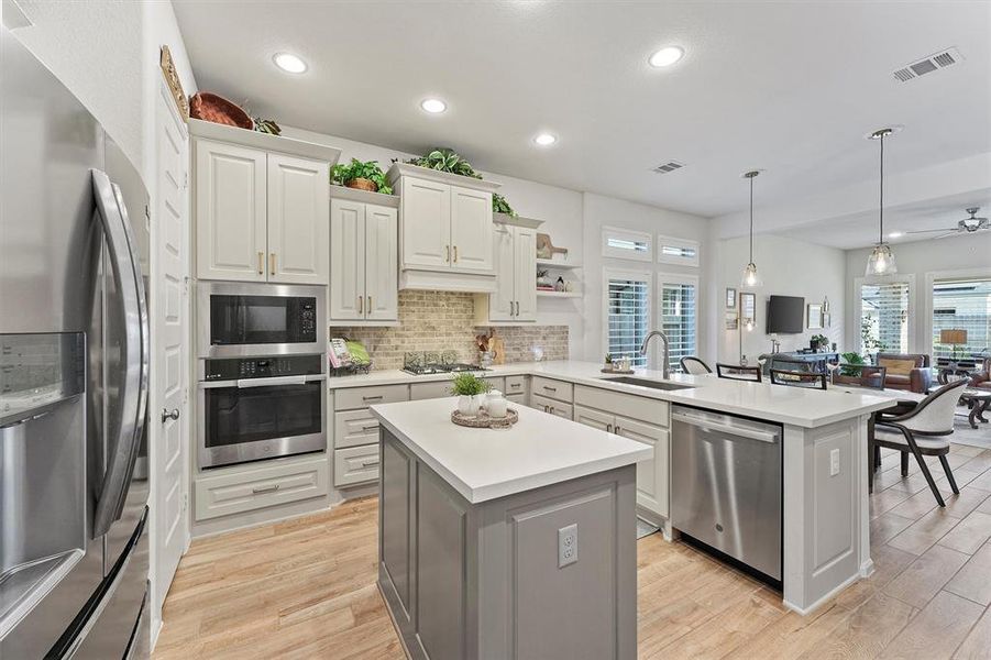 This gourmet kitchen boasts a gas cooktop, custom hardware, accented paint colors, and upgraded cabinetry.