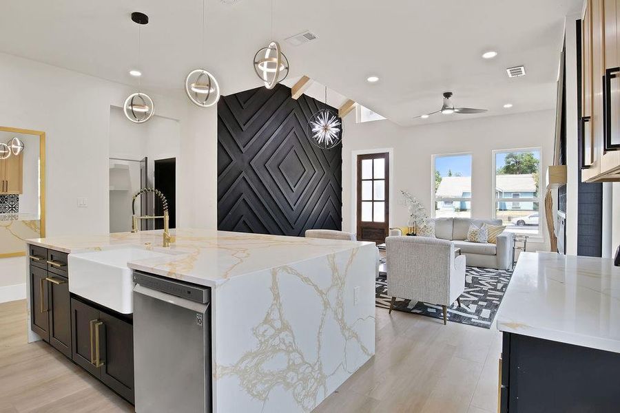 Kitchen featuring dishwasher, pendant lighting, an island with sink, and ceiling fan