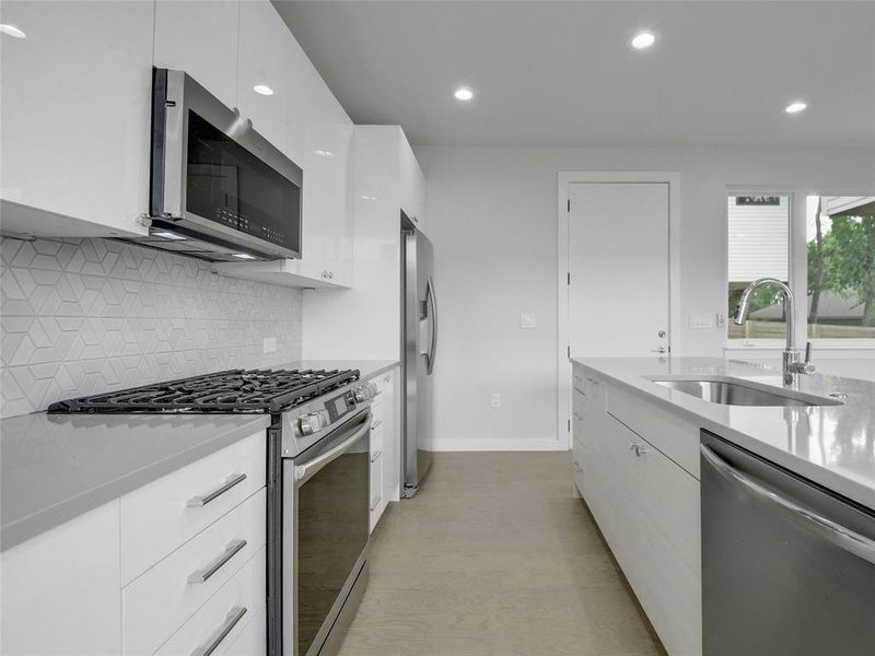 Ample cabinetry and storage space ensure organization and functionality in this modern kitchen.