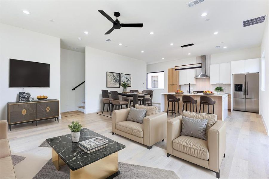 Living room with sink, light wood-type flooring, and ceiling fan