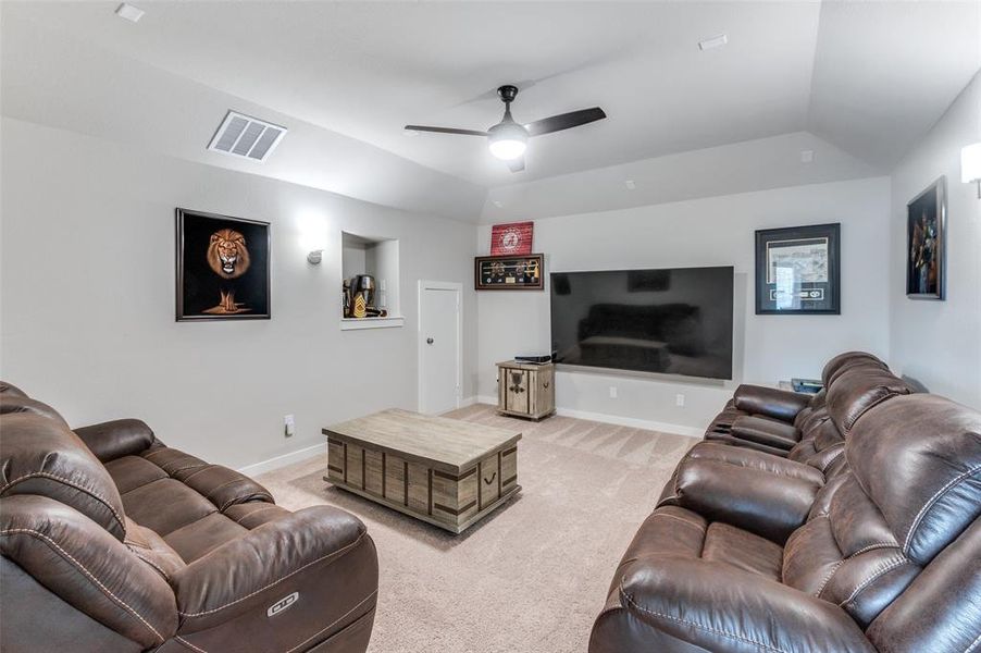 Carpeted living room with ceiling fan