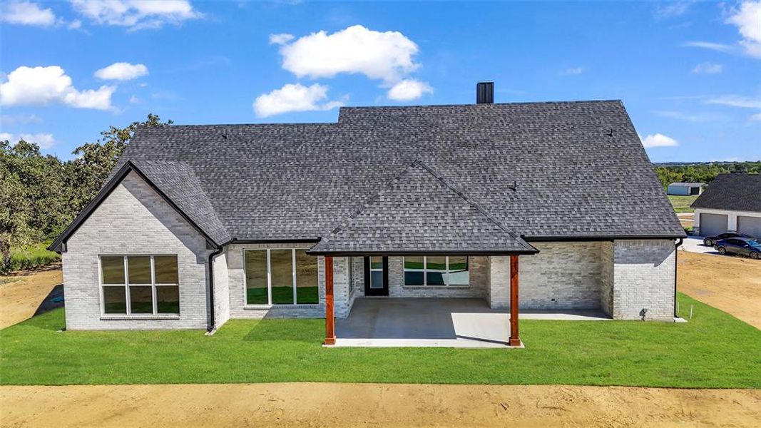 Rear view of property featuring a yard and a patio