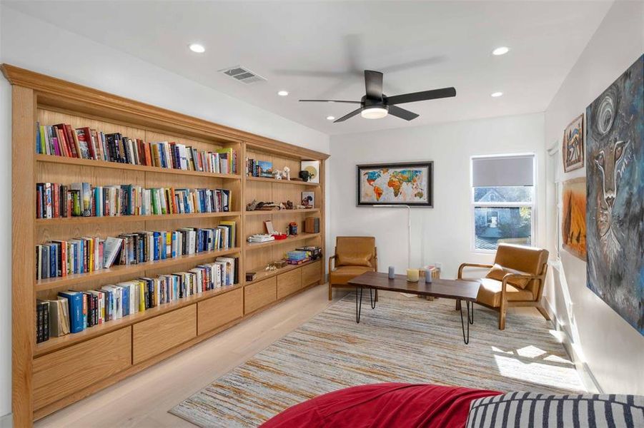 The loft area is versatile, ideal for a home office, reading nook, or additional lounge space. Built-in bookcases provide ample storage for books, decor, and personal items, adding functionality.