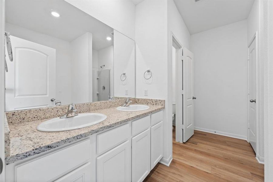 The primary bathroom includes granite countertops, double vanities, soaking tub, walk-in shower and enclosed water closet.
