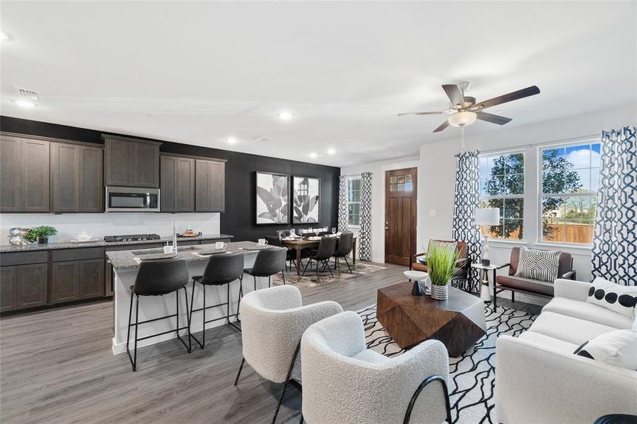 Living room with ceiling fan and light hardwood / wood-style flooring