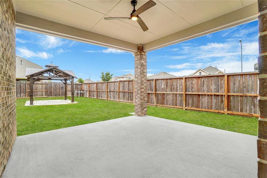 This is a spacious, covered patio that includes a gas line and ceiling fan