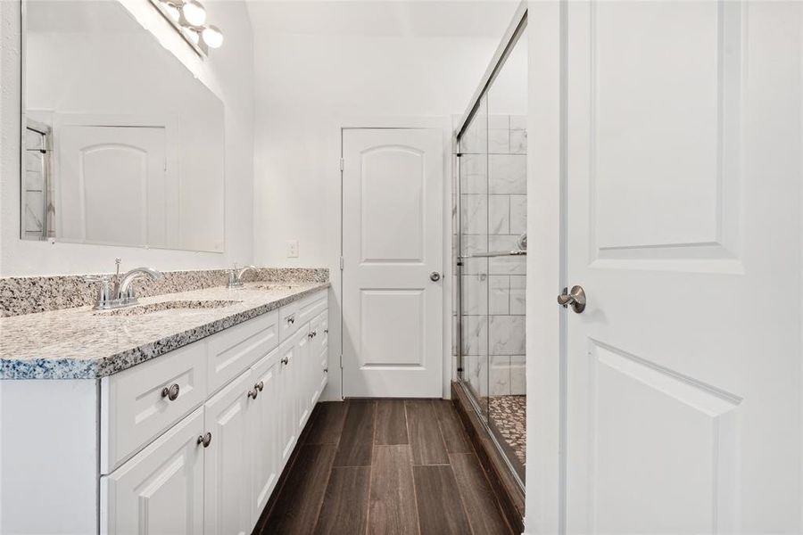 Bathroom featuring vanity, a shower with shower door, and hardwood / wood-style flooring