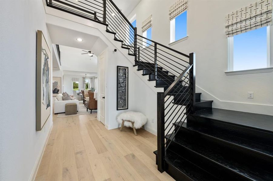 Stairway featuring wood-type flooring and a towering ceiling